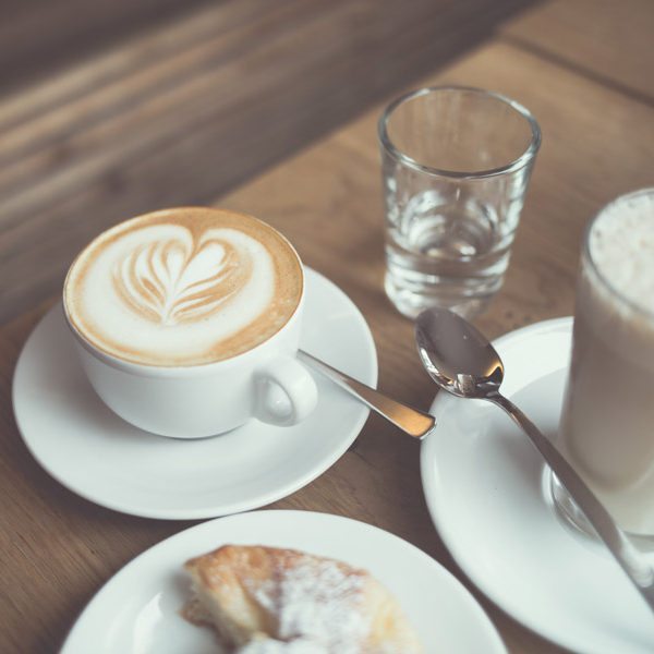 Coffee cups and cakes on a table