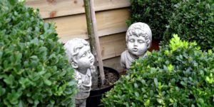 Children statues among the hedges